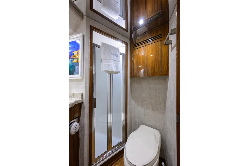 Torta Yacht Photos Pics Luxurious bathroom in 2017 Viking 72 Enclosed Bridge yacht with shower and wooden cabinetry.