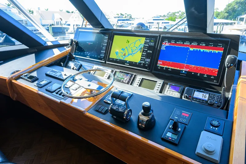 Torta Yacht Photos Pics Control panel of 2017 Viking 72 Enclosed Bridge yacht with navigation screens and steering wheel.