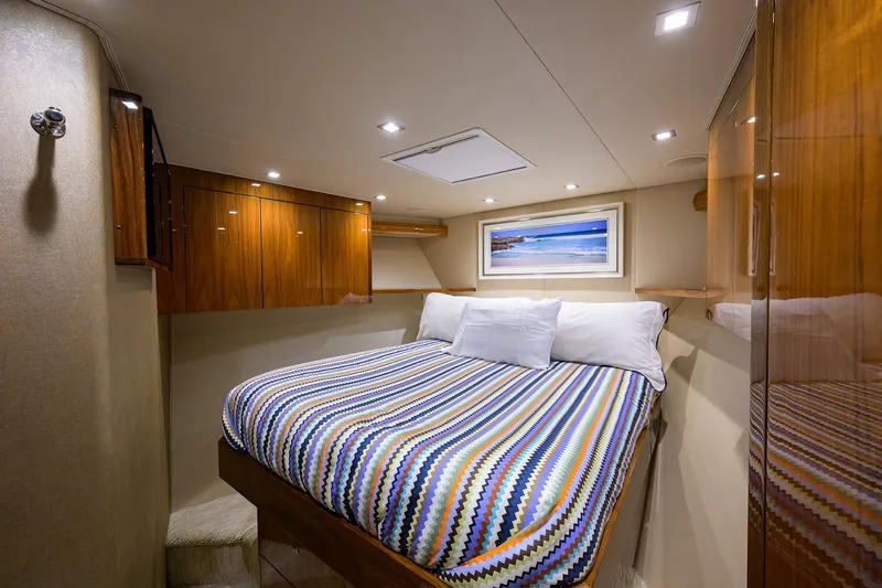 Torta Yacht Photos Pics Luxurious cabin interior of 2017 Viking 72 Enclosed Bridge yacht with cozy bed and wood finishes.