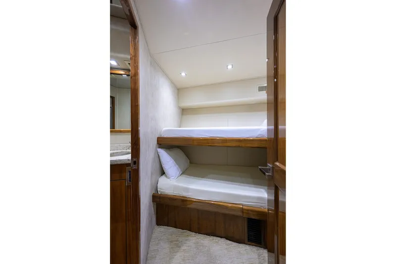 Torta Yacht Photos Pics Bunk beds in 2017 Viking 72 Enclosed Bridge yacht cabin, featuring wooden accents and modern lighting.