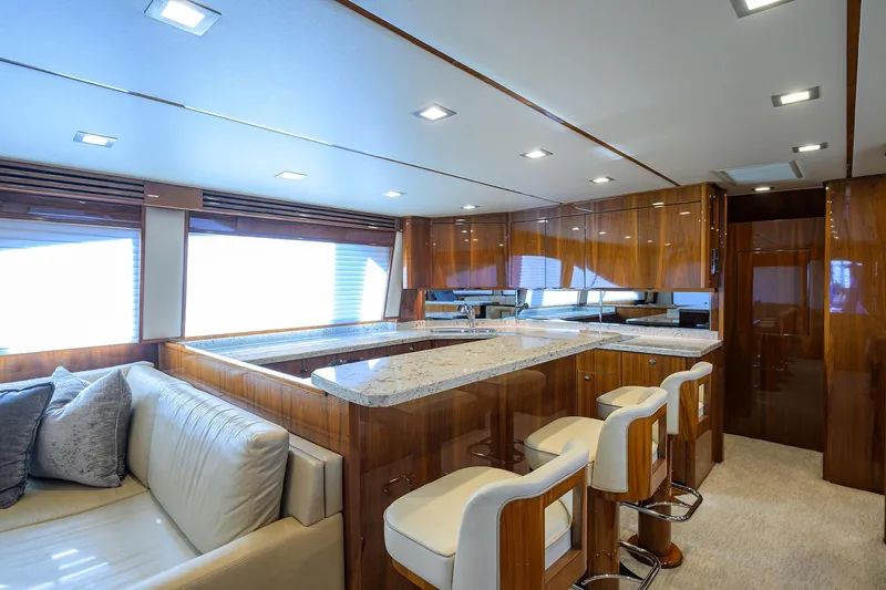 Torta Yacht Photos Pics Luxurious interior of 2017 Viking 72 Enclosed Bridge yacht with elegant wood finishes and modern seating.