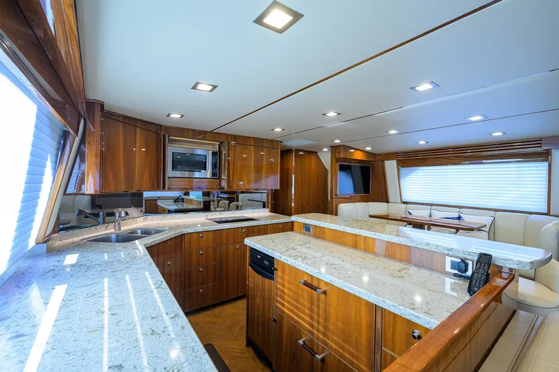 Torta Yacht Photos Pics Luxurious interior of 2017 Viking 72 Enclosed Bridge yacht with modern kitchen and seating area.