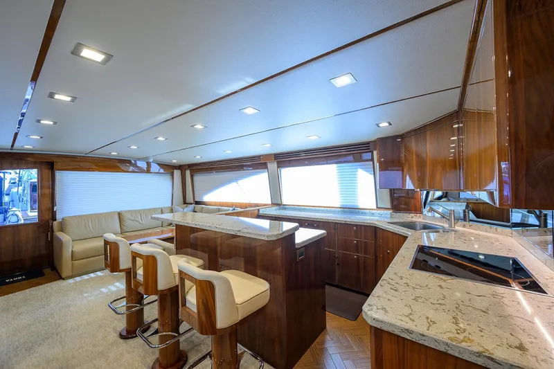 Torta Yacht Photos Pics Luxurious interior of 2017 Viking 72 Enclosed Bridge yacht with modern kitchen and seating area.