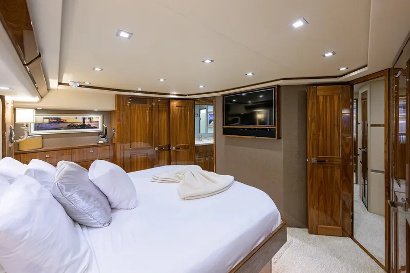 Torta Yacht Photos Pics Luxurious 2017 Viking 72 Enclosed Bridge yacht bedroom with elegant wood finishes and modern amenities.