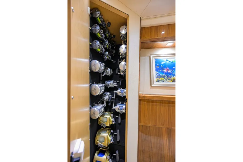 Torta Yacht Photos Pics Fishing rod storage on 2017 Viking 72 Enclosed Bridge yacht, featuring multiple reels and wooden interior.