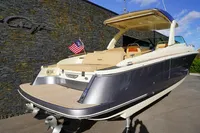 2024 Chris-Craft Launch 35GT boat with American flag, docked under clear blue sky.