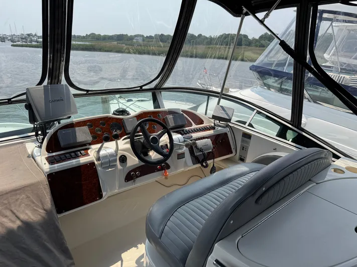 Knot On Call II Yacht Photos Pics 2000 Maxum 4600 SCB yacht helm with steering wheel, navigation equipment, and water view.
