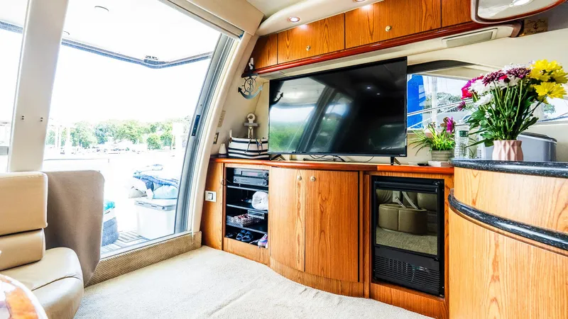 Knot On Call II Yacht Photos Pics Luxurious interior of 2000 Maxum 4600 SCB yacht with TV, wooden cabinets, and floral decor.
