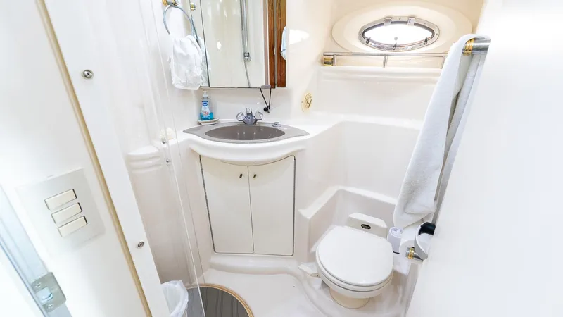 Knot On Call II Yacht Photos Pics Luxurious bathroom in 2000 Maxum 4600 SCB yacht, featuring sink, toilet, and porthole window.
