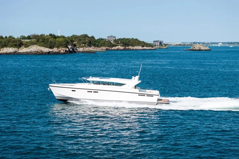  Yacht Photos Pics 2017 Delta Powerboats 54 IPS cruising on blue ocean near rocky coastline.