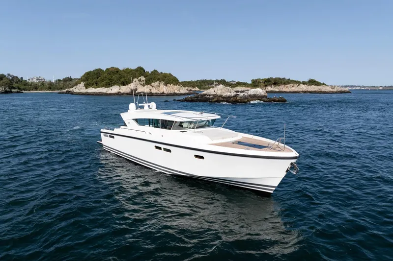  Yacht Photos Pics 2017 Delta Powerboats 54 IPS cruising on open water near rocky islands.