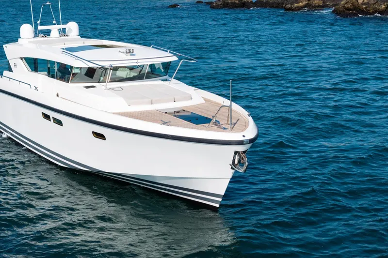  Yacht Photos Pics 2017 Delta Powerboats 54 IPS cruising on open water near rocky shoreline.