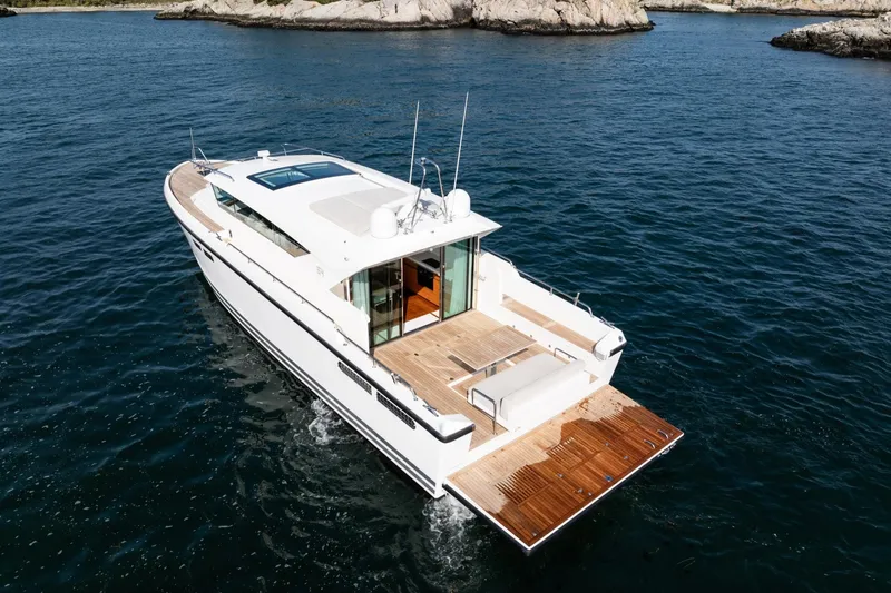  Yacht Photos Pics 2017 Delta Powerboats 54 IPS cruising on open water near rocky coastline.