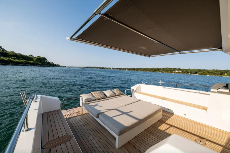  Yacht Photos Pics Luxurious 2017 Delta Powerboats 54 IPS yacht deck with sunshade, overlooking serene waters.