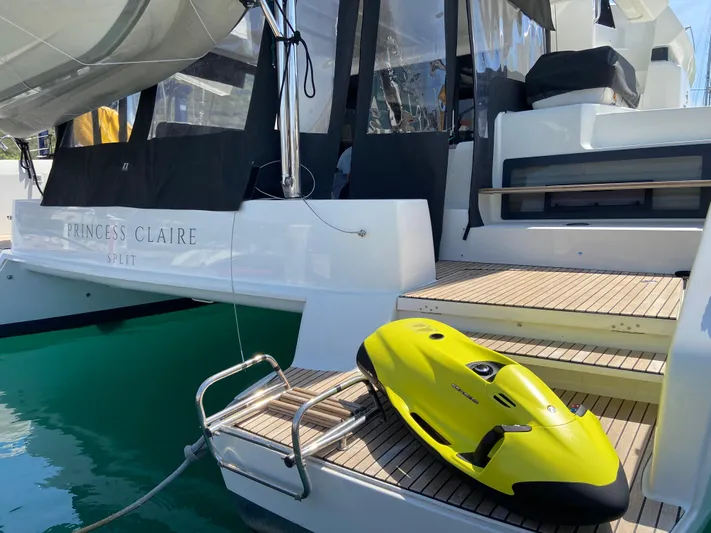  Yacht Photos Pics 2019 Lagoon 50 yacht with yellow water scooter on deck, docked in clear water.