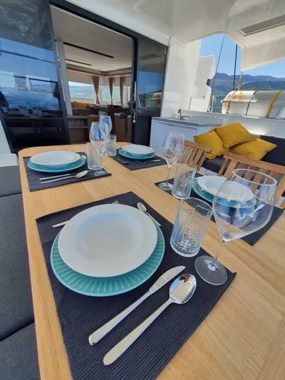  Yacht Photos Pics Elegant dining setup on Lagoon 50 yacht, featuring modern tableware and scenic views.
