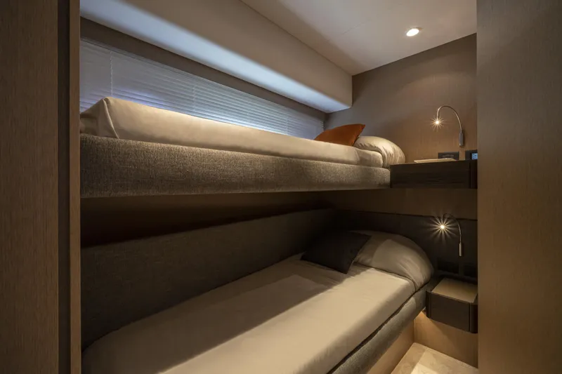  Yacht Photos Pics Luxurious 2023 Ferretti Yachts 500 cabin with modern bunk beds and ambient lighting.