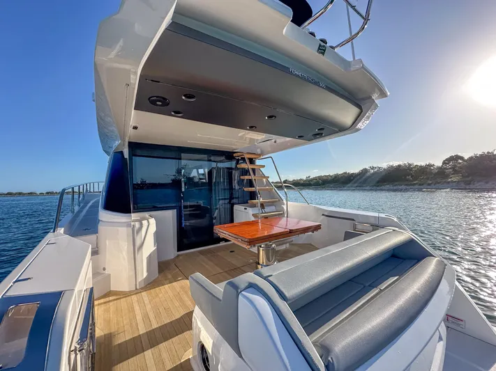  Yacht Photos Pics 2023 Ferretti Yachts 500, luxurious deck with seating, table, and scenic water view.