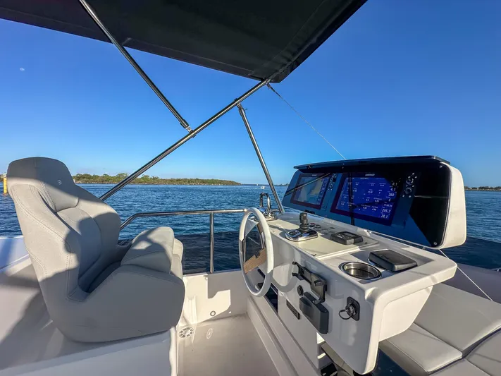  Yacht Photos Pics 2023 Ferretti Yachts 500 helm with modern controls, overlooking serene blue waters.