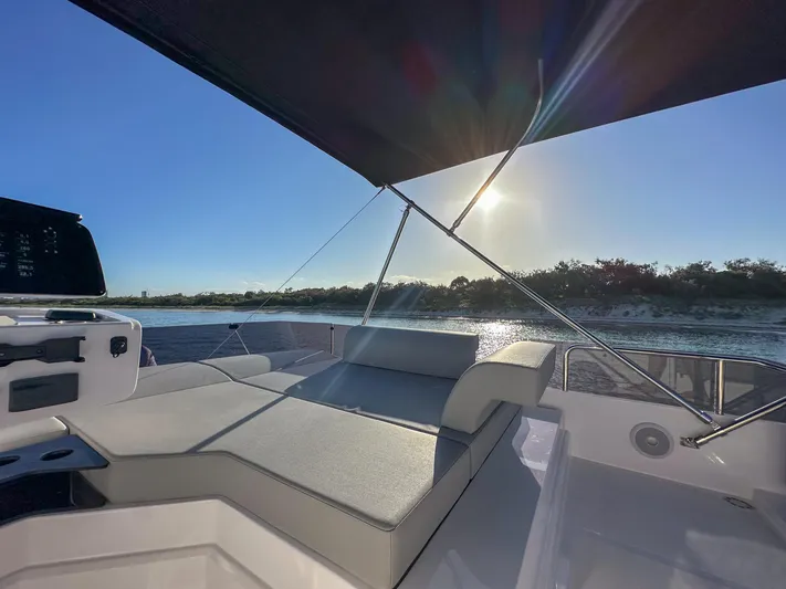  Yacht Photos Pics 2023 Ferretti Yachts 500 deck with sunshade, overlooking serene water and sunset.