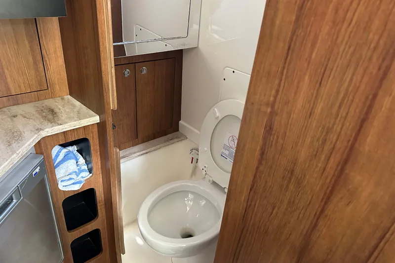  Yacht Photos Pics Compact bathroom in 2018 Invincible 42 boat with wooden cabinetry and modern fixtures.