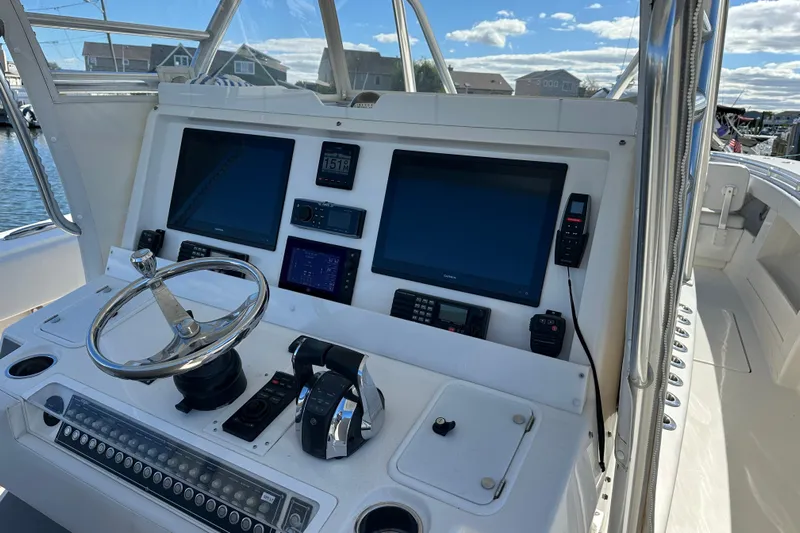  Yacht Photos Pics Control panel of a 2018 Invincible 42 boat with navigation screens and steering wheel.