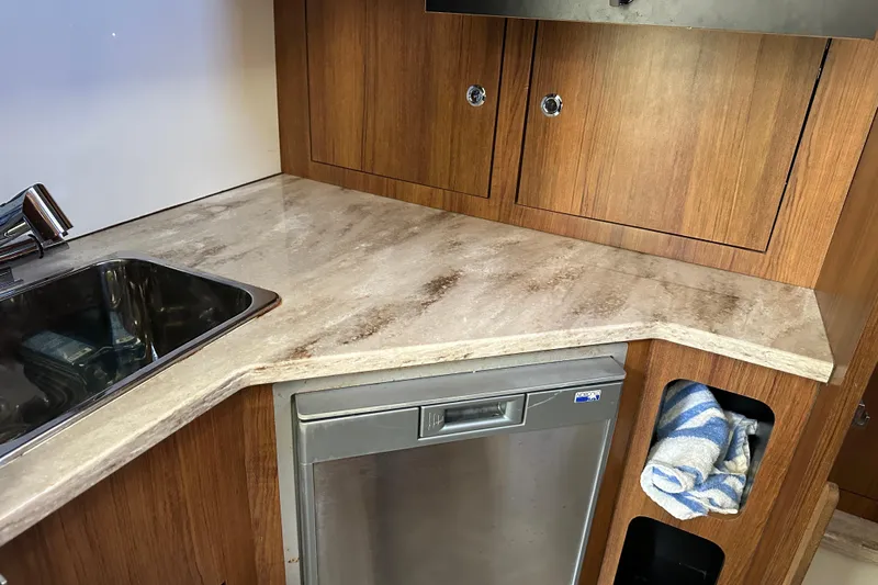  Yacht Photos Pics Compact kitchen area in 2018 Invincible 42 boat with sink, countertop, and storage.