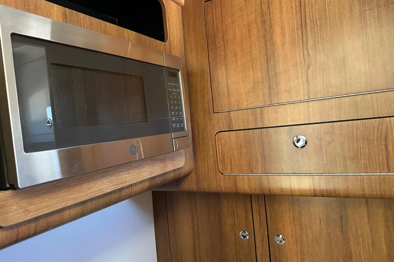  Yacht Photos Pics Microwave and wooden cabinetry inside a 2018 Invincible 42 model boat kitchen.