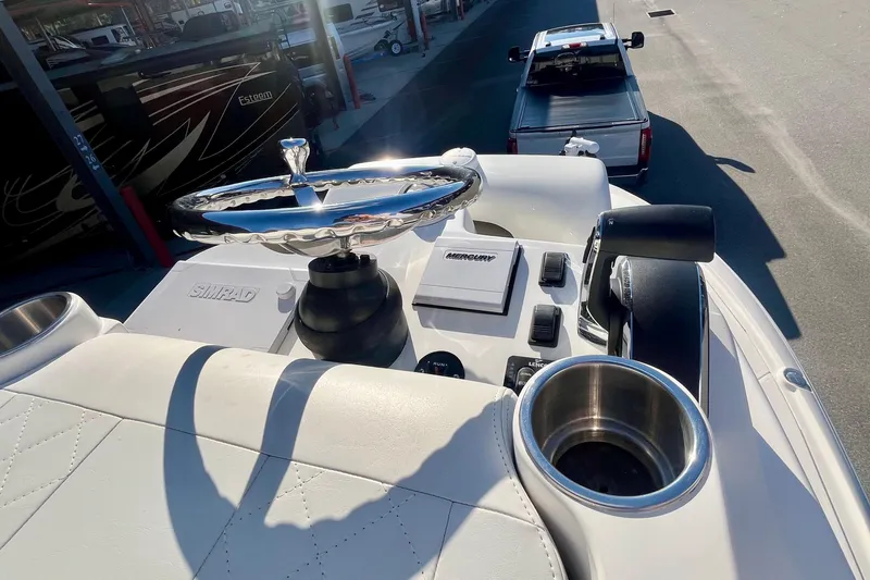  Yacht Photos Pics 2018 SeaVee 270Z boat helm with steering wheel, controls, and cup holder in sunlight.