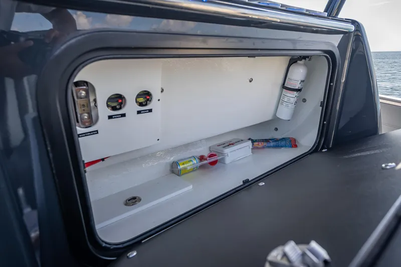  Yacht Photos Pics Storage compartment in 2024 Nor-Tech 390 Sport Center Console boat with safety equipment.