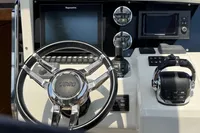 Control panel of a 2015 Fjord 40 Open boat with steering wheel and navigation screens.