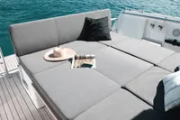 Luxurious sunbed on 2015 Fjord 40 Open yacht, with hat and magazine, overlooking blue water.