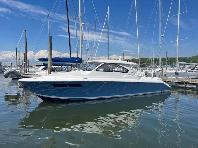  Yacht Photos Pics 2019 Pursuit DC 365 Dual Console boat docked in a marina under a clear blue sky.