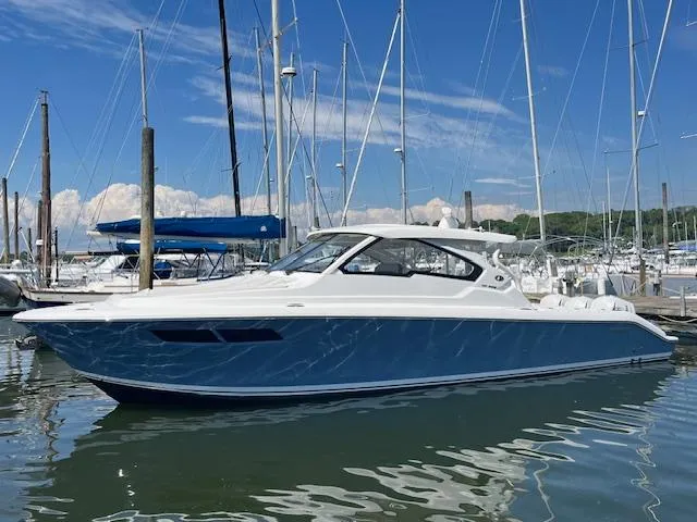  Yacht Photos Pics 2019 Pursuit DC 365 Dual Console boat docked in a marina under a clear blue sky.