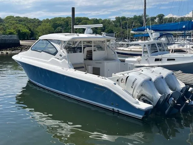 Yacht Photos Pics 2019 Pursuit DC 365 Dual Console boat docked in a marina, featuring twin outboard engines.