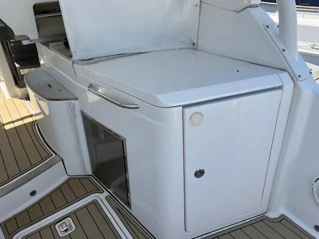  Yacht Photos Pics 2019 Pursuit DC 365 Dual Console boat interior with sleek white cabinetry and teak flooring.