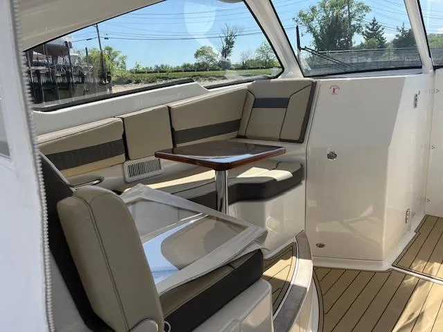  Yacht Photos Pics 2019 Pursuit DC 365 Dual Console interior with seating and table, featuring modern design and comfort.