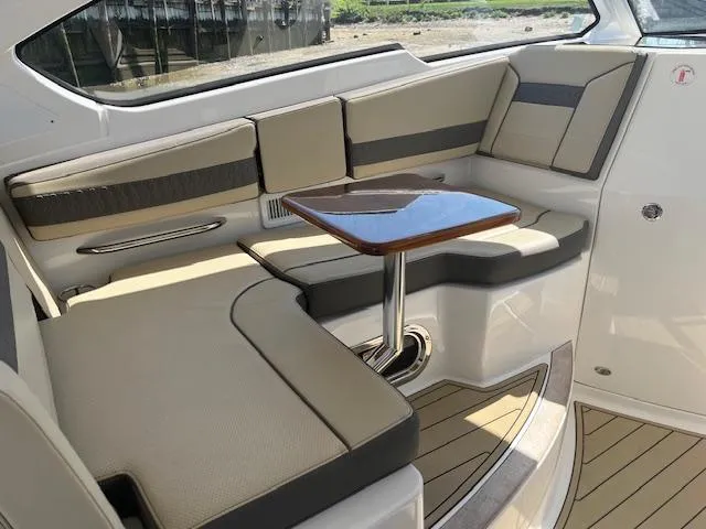  Yacht Photos Pics 2019 Pursuit DC 365 Dual Console interior with beige seating and wooden table.