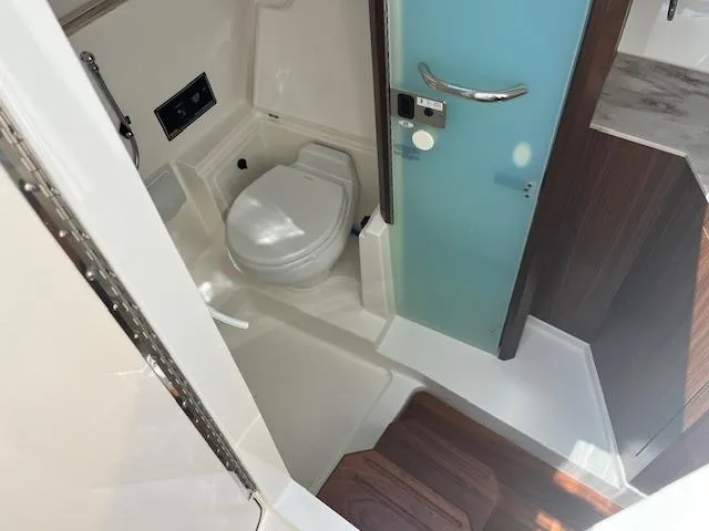  Yacht Photos Pics 2019 Pursuit DC 365 Dual Console boat bathroom with modern fixtures and wooden accents.