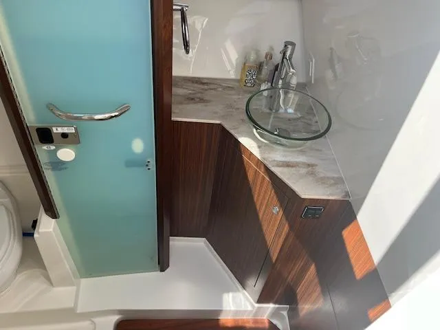  Yacht Photos Pics 2019 Pursuit DC 365 Dual Console bathroom with glass sink and modern fixtures.