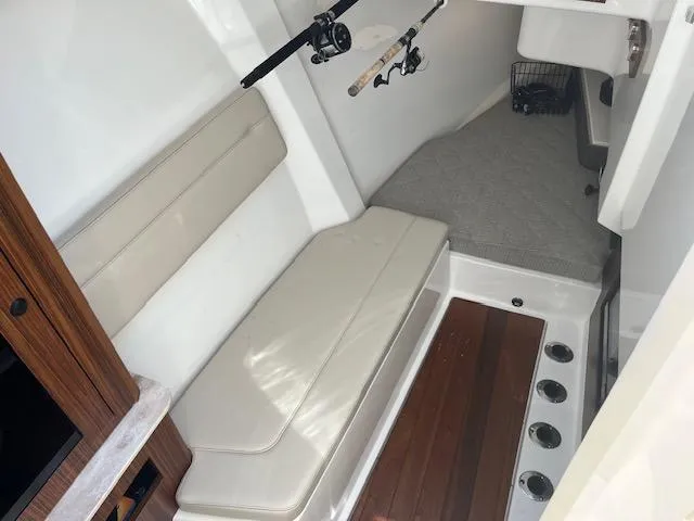  Yacht Photos Pics 2019 Pursuit DC 365 Dual Console interior with seating, fishing rods, and wooden flooring.