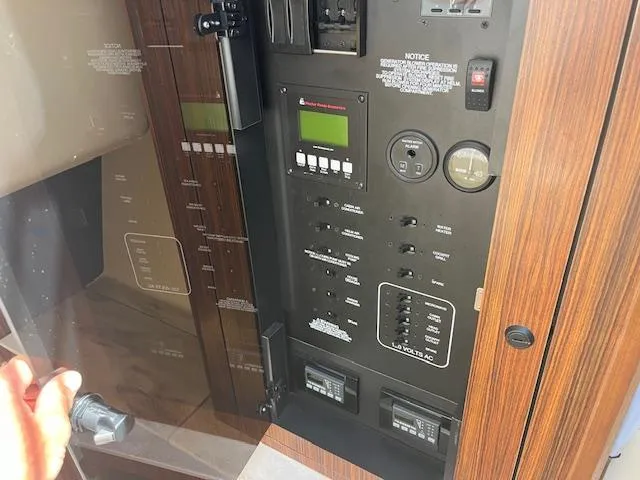  Yacht Photos Pics Control panel of a 2019 Pursuit DC 365 Dual Console boat, featuring various switches and displays.