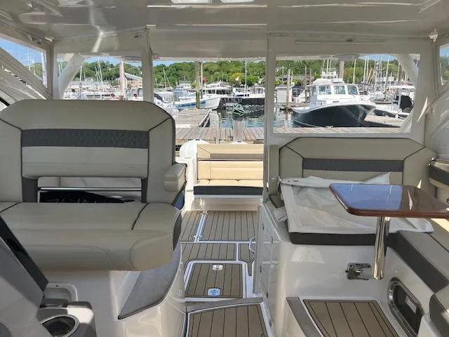  Yacht Photos Pics 2019 Pursuit DC 365 Dual Console interior with seating, table, and marina view.