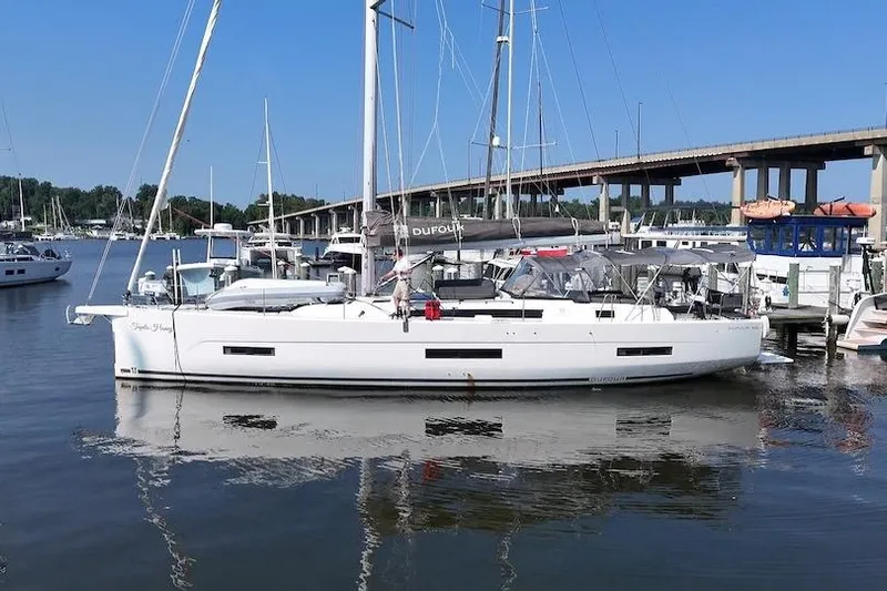 Tupelo Honey Yacht Photos Pics 2022 Dufour 530 sailboat docked in a marina, clear blue sky background.