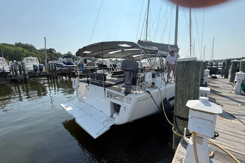 Tupelo Honey Yacht Photos Pics 2022 Dufour 530 yacht docked at marina, featuring spacious deck and canopy.