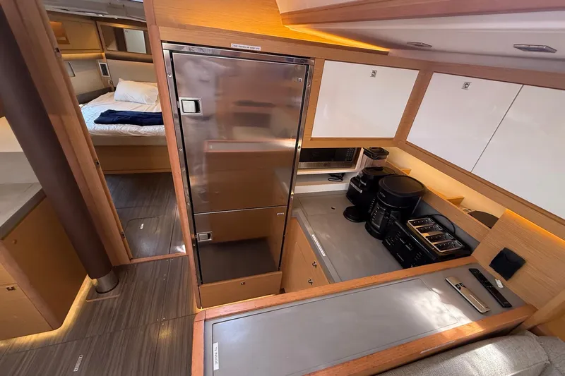 Tupelo Honey Yacht Photos Pics Modern kitchen interior of 2022 Dufour 530 yacht with appliances and cozy bedroom view.