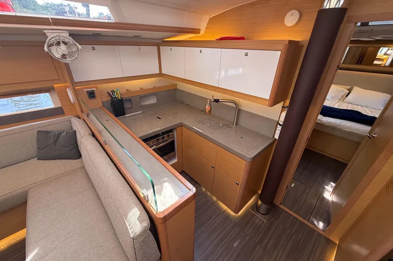 Tupelo Honey Yacht Photos Pics Modern kitchen interior of 2022 Dufour 530 yacht with sleek cabinetry and cozy seating area.
