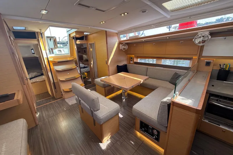 Tupelo Honey Yacht Photos Pics Luxurious interior of 2022 Dufour 530 yacht with modern seating and kitchen area.
