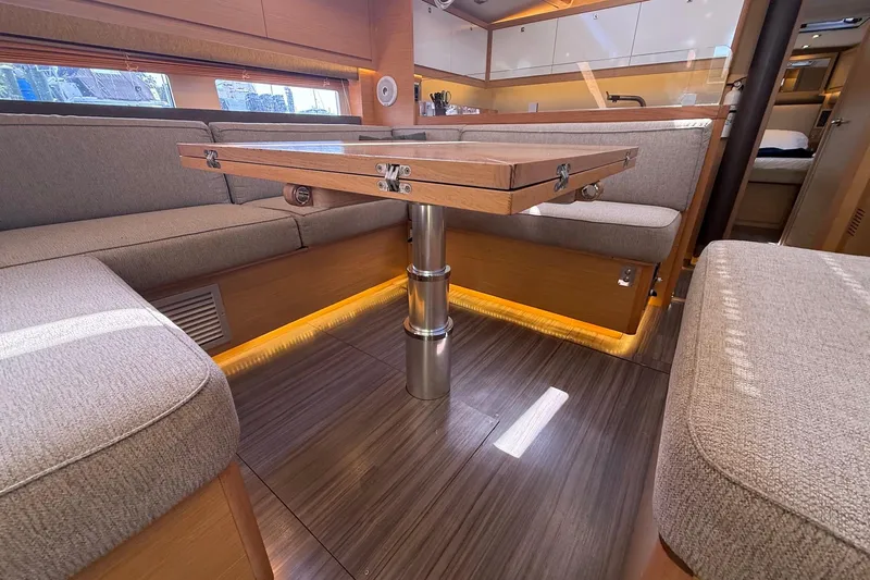 Tupelo Honey Yacht Photos Pics Interior of 2022 Dufour 530 yacht, featuring elegant seating and a wooden table.