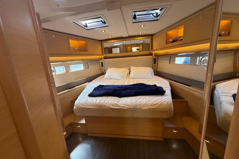 Tupelo Honey Yacht Photos Pics Luxurious cabin interior of 2022 Dufour 530 yacht with cozy bedding and modern design.